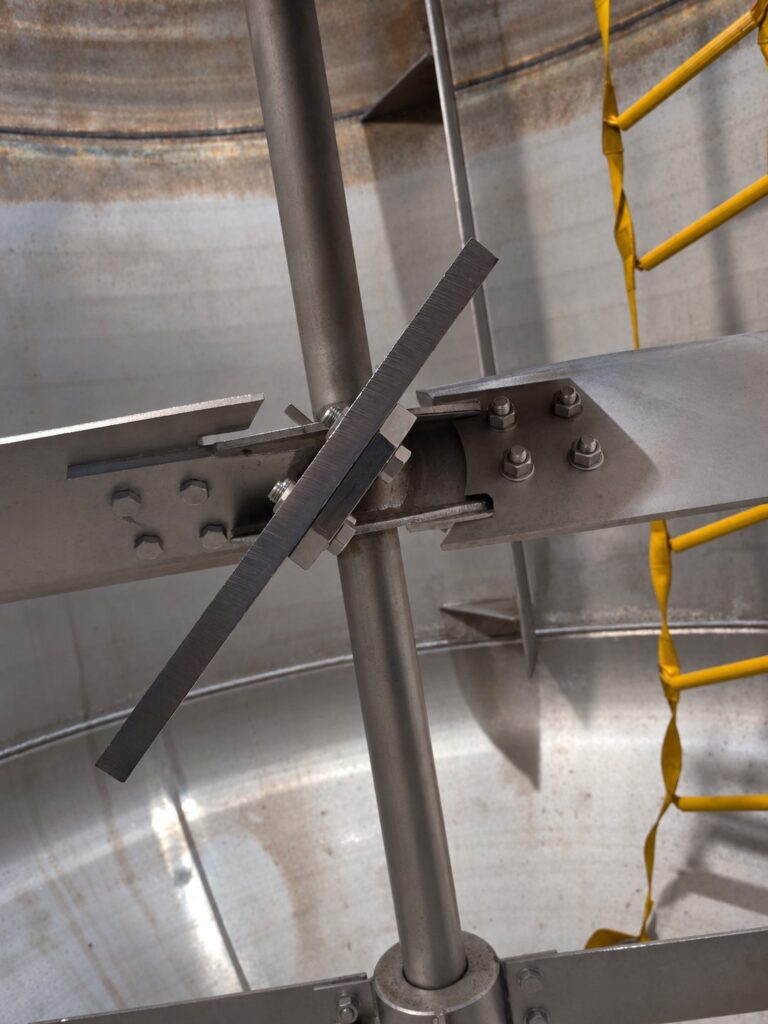 Installed pitched blade turbine and mixer shaft inside a stainless steel vessel.