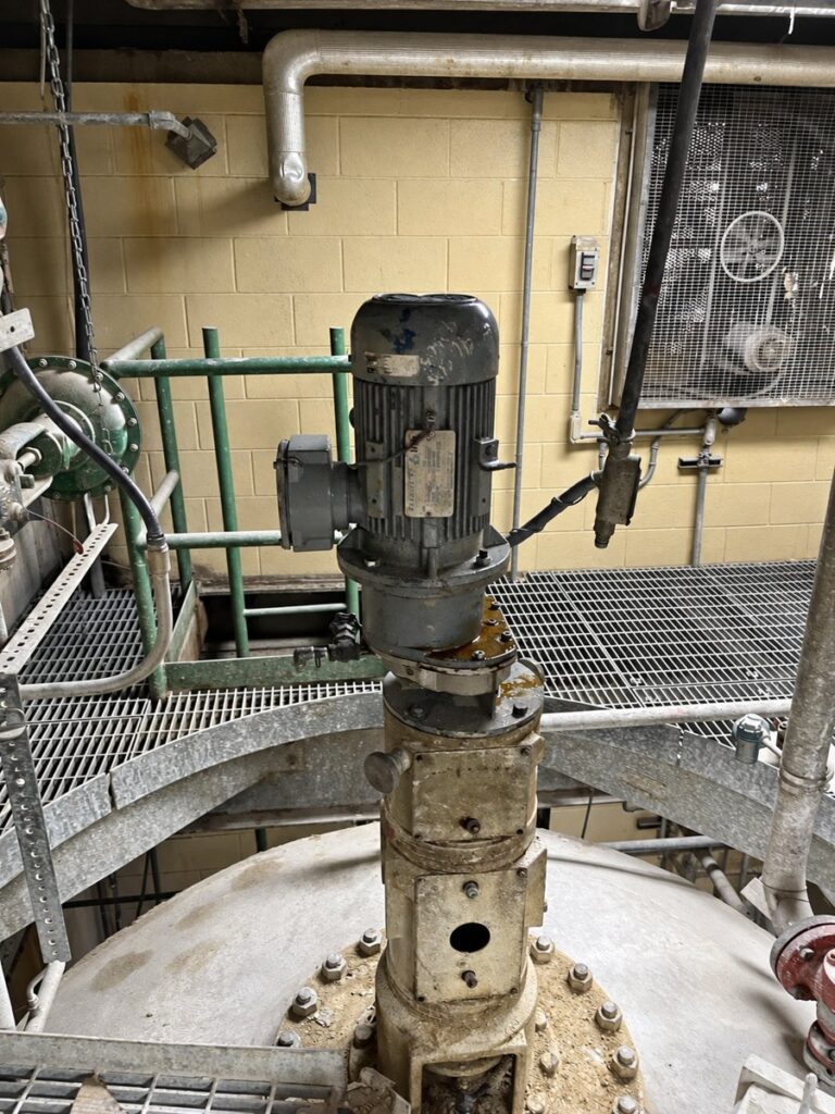 Top entry mixer drive installed in service on a vessel head, with the motor and right angle gear reducer on a flanged mount.