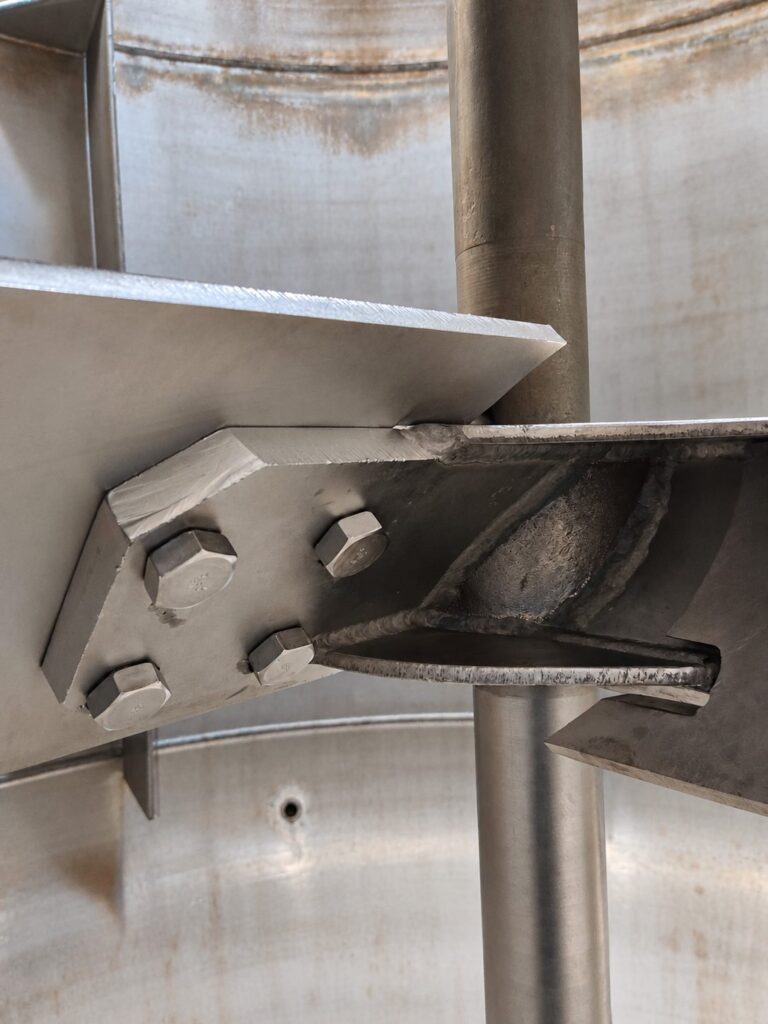 Close view of a pitched blade turbine hub and bolted blade mounting tab.