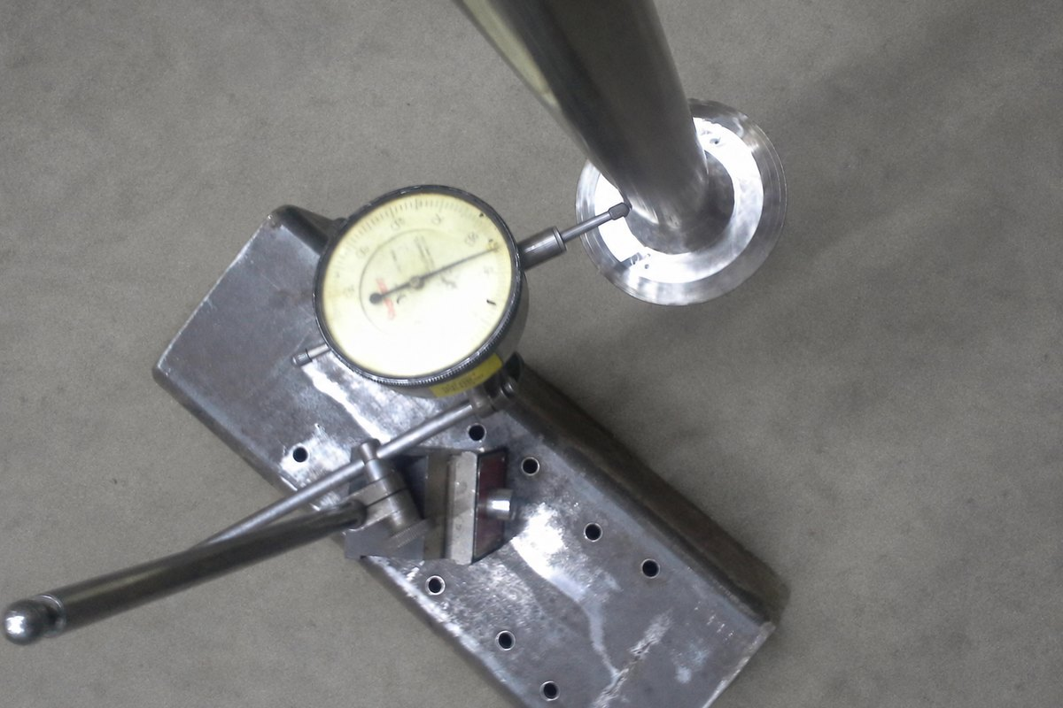Dial indicator mounted against a mixer shaft to measure runout during a drive rebuild.